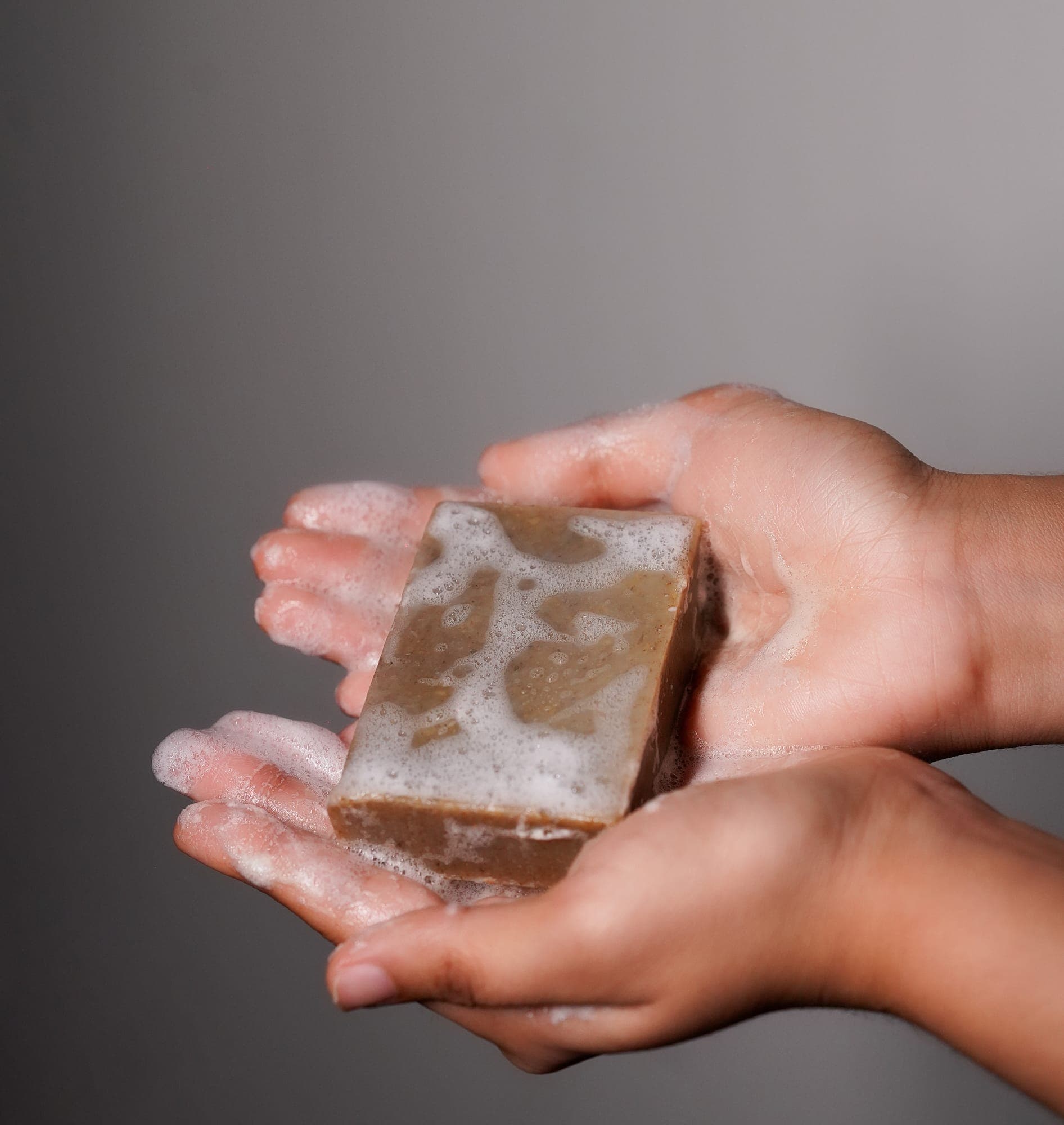 A freshly poured Soapy Poetry bar, lathered in a pair of hands