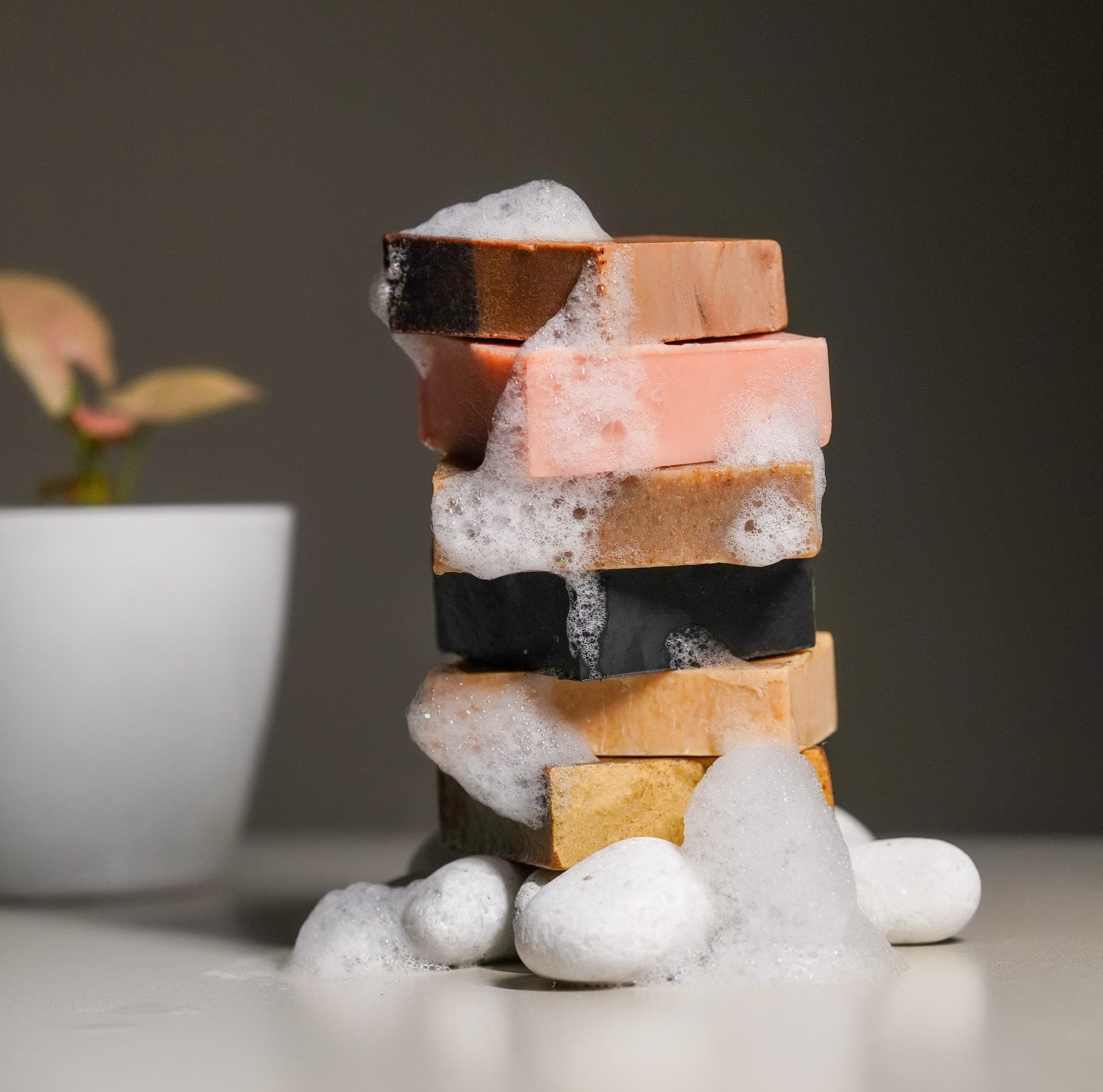A tower of cured soap bars beside a fresh plant