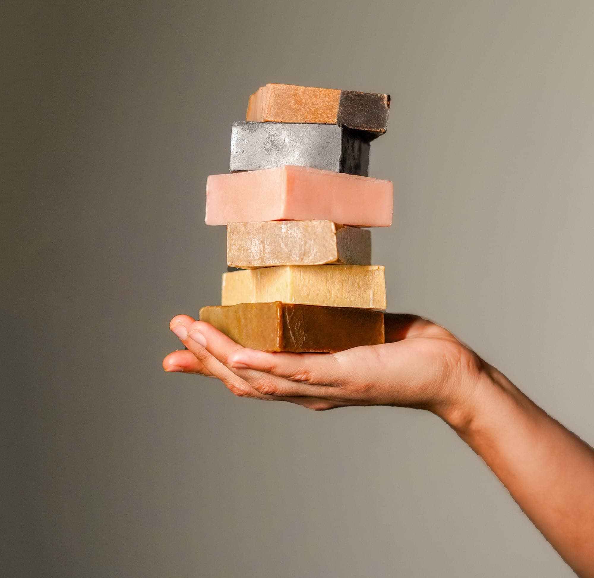 A hand presenting a stack of handmade bars